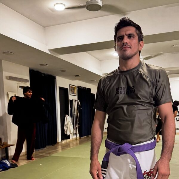 Amjad Khan in a rash guard and purple belt on the mats